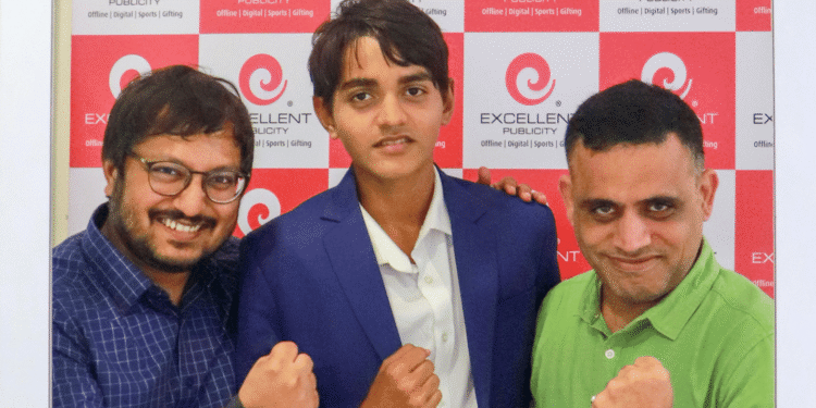 Teenager Yug Parikh seated in the CEO chair at Excellent Publicity headquarters during the 14th anniversary celebrations, interacting with leadership and participating in brand strategy sessions