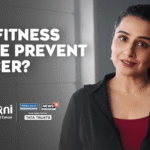 Vidya Balan seated in a film set styled for health messaging, surrounded by symbolic visuals promoting cancer screening with a calm and confident expression