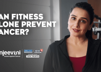 Vidya Balan seated in a film set styled for health messaging, surrounded by symbolic visuals promoting cancer screening with a calm and confident expression